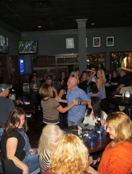 A couple dancing to the music at a piano bar show.